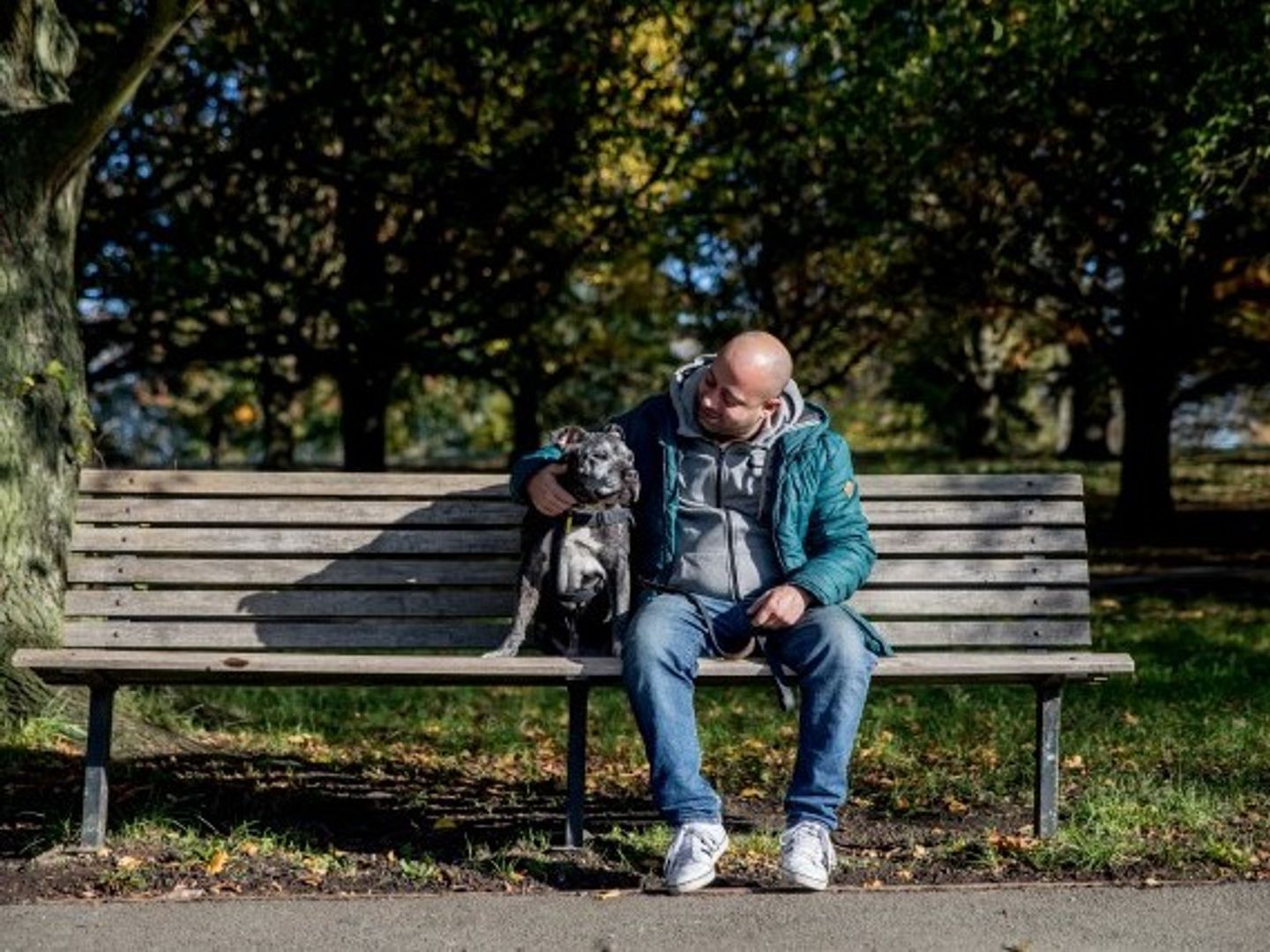 Dog owner Paul sitting on a park bench with his dog Blake