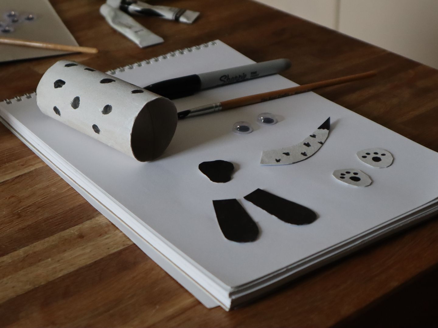 Cardboard loo roll tube and accessories crafted to look like a Dalmatian