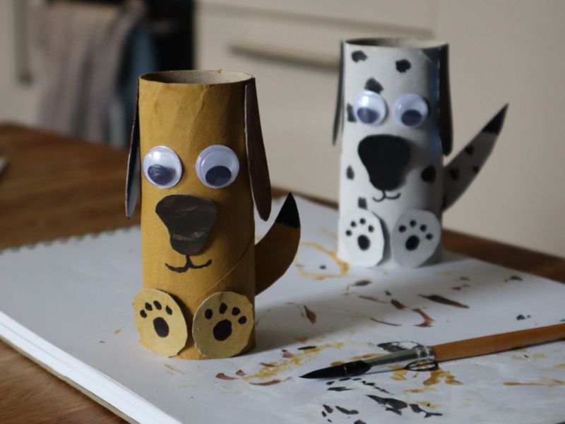 Two cardboard tubes decorated to look like dogs