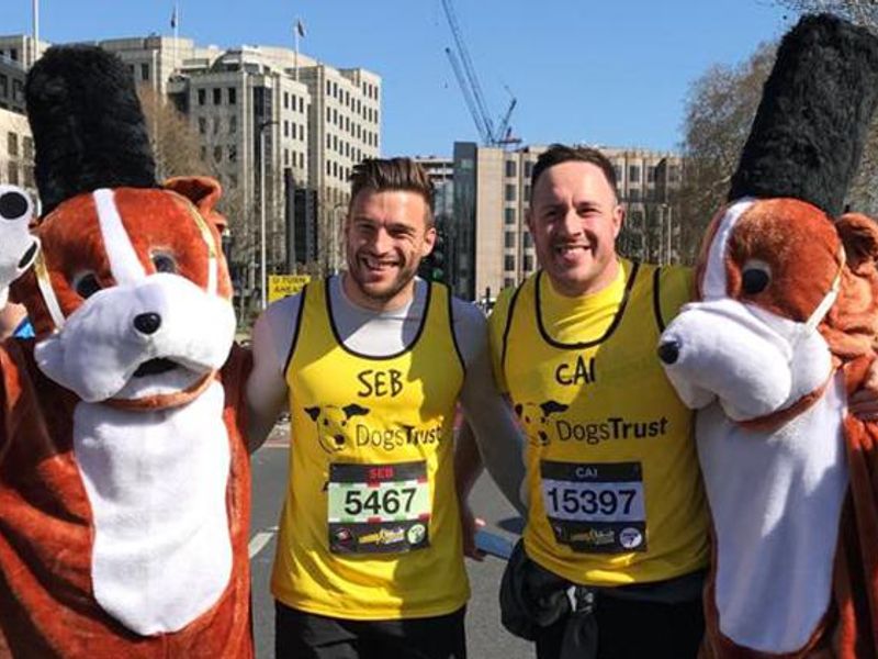 Two male runners at London Landmarks Half Marathon posing next to two people in dog costumes